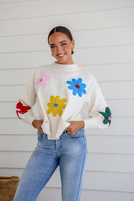 cute and quirky white knit featuring 3D colourful daisy style flowers over it